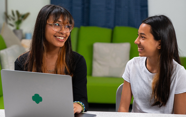 Six Girl Scouts of various ages sitting on a couch together