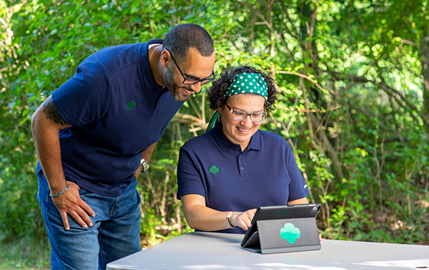 man and women volunteers looking at an ipad